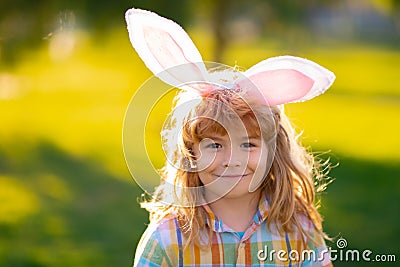 Bunny child boy face. Kids boy in bunny ears outdoor. Child having easter in park. Stock Photo