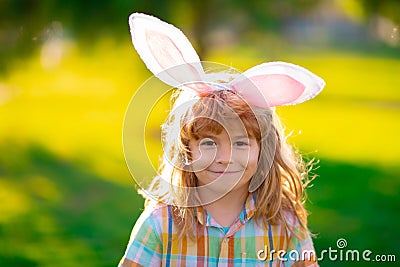 Bunny child. Child boy hunting easter eggs. Child boy with easter eggs and bunny ears in park. Stock Photo