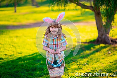 Bunny child. Kids boy hunting easter eggs. Child in bunny ears hunt Easter eggs. Stock Photo