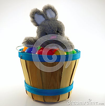 Bunny rabbit sitting on assorted easter eggs on wooden bucket Stock Photo