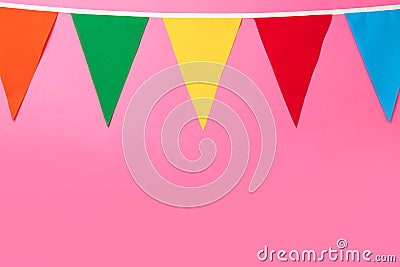 Bunting with colorful triangular flags on pink background. Space for text Stock Photo