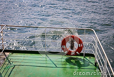 Buoy or lifebuoy ring on shipboard. A device on ship side on seascape. Safety, rescue, life preserver. Water travel, voyage, Stock Photo