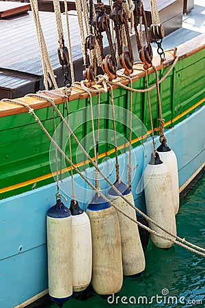 Buoys hanging outside the hull of a colorful wooden sailing boat Stock Photo