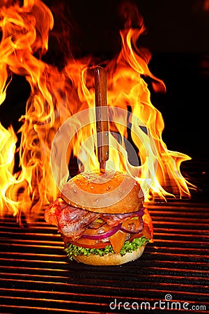 Burger with bacon, chop, lettuce, grilled cheese on a grill Stock Photo