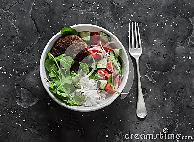 Burger bowl. Beef patty with rice and fresh vegetable salad on a dark background, top view Stock Photo