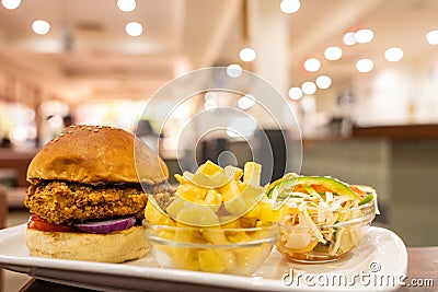 Burger, a bowl of french fries and salad on a plate Stock Photo