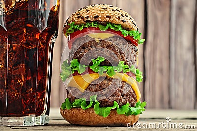 Burger and cola with ice on a wooden background Stock Photo