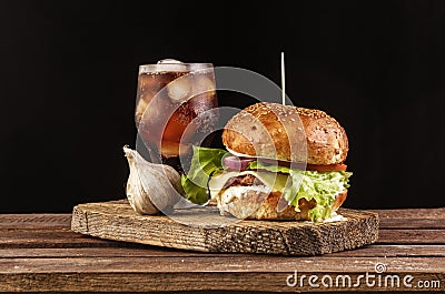 Burger with garlic and cola on wooden cutting board with copyspace Stock Photo