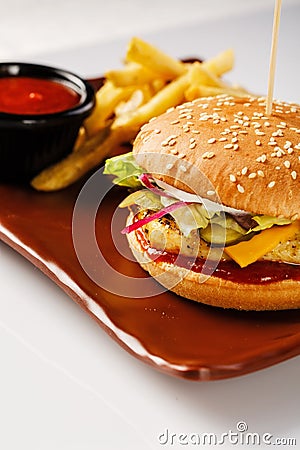 Burger. Juicy pork cutlet, cheddar cheese, crispy pickled onions, lettuce wrapped in a bun under two sauces. Served with Stock Photo