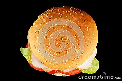 Burger with lettuce, tomato, cheese and cutlet top view. Classic cheeseburger with beef, cheese, tomato on black background. Top Stock Photo