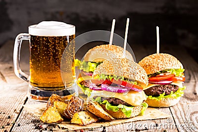 Burgers with beef and fried potatoes and glass of cold beer Stock Photo