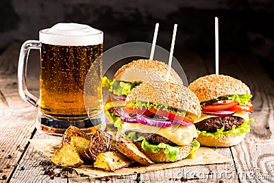 Burgers with beef and fried potatoes and glass of cold beer Stock Photo