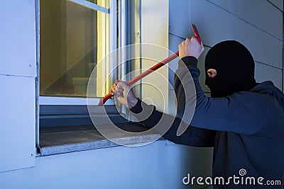 Burglar Using Crowbar To Break Into A House Stock Photo