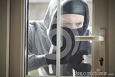 Burglar Breaking Into House By Forcing Door With Crowbar Stock Photo