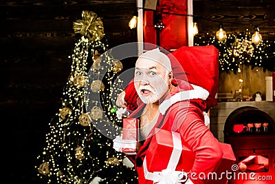 Burglar man dressed in Santa wearing a Santa hat. Thief Santa with bag on christmas background. Thief stole new years Stock Photo