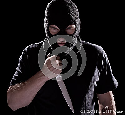 Burglar in mask holding knife Stock Photo