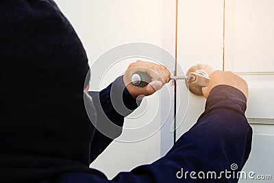 Burglar trying to break into a house Stock Photo