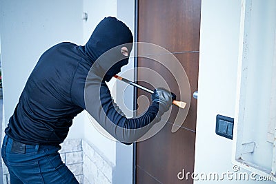 Burglar trying to force a door Stock Photo