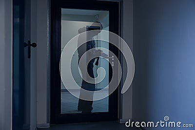 Burglar Using Crowbar To Open Glass Door Stock Photo