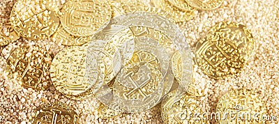 Buried Pirate Treasure Gold Coins in the Sand on a Sandy Beach Stock Photo