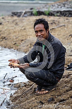 Burmese man holding freshwater fish Editorial Stock Photo