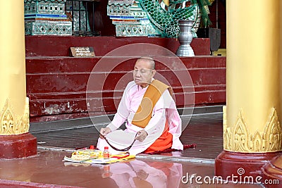 Burmese nuns sitting and praying in front of Shwedagon pagoda 1 of 5 sacred places Editorial Stock Photo