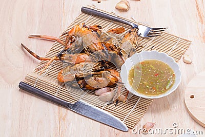 Burn shrim and Seafood sauce on wooden table. Stock Photo