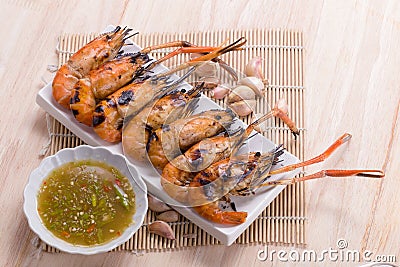 Burn shrim and Seafood sauce on wooden table. Stock Photo