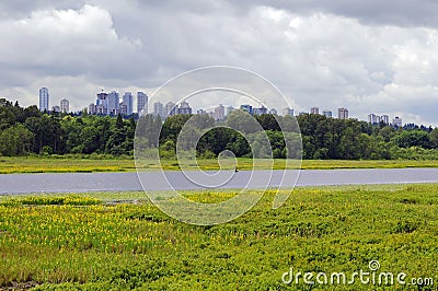 Burnaby Lake surrounded by grass, flowers and trees Stock Photo