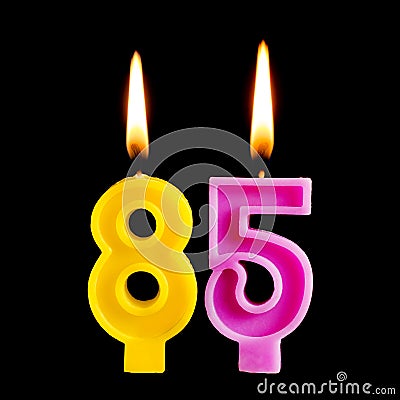 Burning birthday candles in the form of 85 eighty five figures for cake isolated on black background. The concept of celebrating a Stock Photo