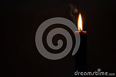 Burning black thin candle for a magical ritual, Halloween or occultism Stock Photo