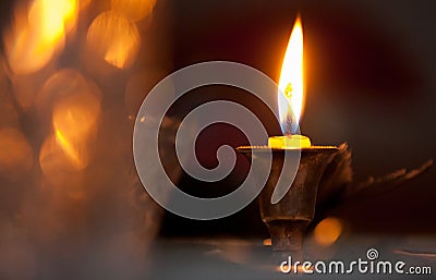 A burning candle in a bronze candlestick on a festive table with Stock Photo