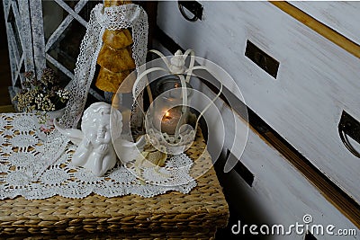 Burning candle, lace, old chest of drawers shabby chic, white angel figurine, wooden mannequin, flowers, concept of family tree, Stock Photo