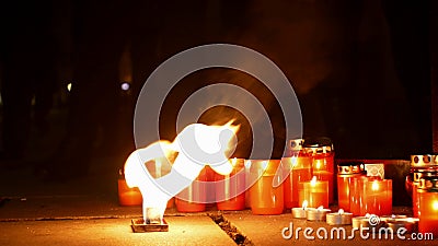 Burning candles as a monument to the death of a man, flames of the fiery fire red, a place in the square, a magical Stock Photo