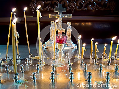 Burning candles before the crucifix in the interior of an Orthodox church Stock Photo