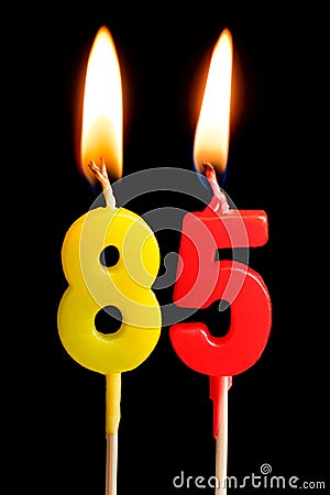 Burning candles in the form of 85 eighty five figures numbers, dates for cake isolated on black background. The concept of cel Stock Photo