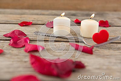 Burning candles surrounded with aromatic rose petals Stock Photo