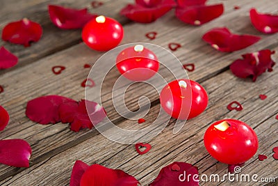 Burning candles surrounded with aromatic rose petals Stock Photo
