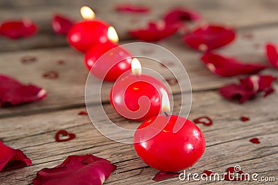 Burning candles surrounded with aromatic rose petals Stock Photo