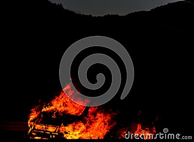 Burning car on the road at night, a tragic accident ending with Stock Photo