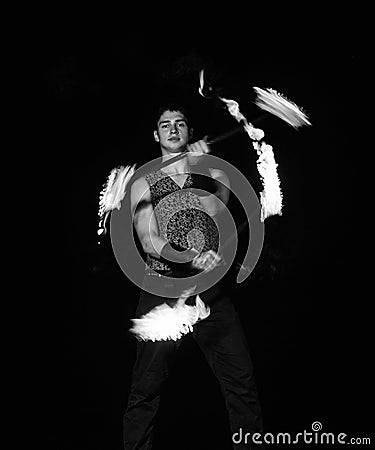Burning energy. Handsome man juggle flaming batons. Fire juggling. Fire energy. Energetic twirling. Flame and sparks Stock Photo
