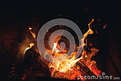 Burning fire logs with sparks in the fireplace Stock Photo