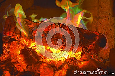 Burning firewood woods in the fireplace and green orange fire. with hot coals Stock Photo