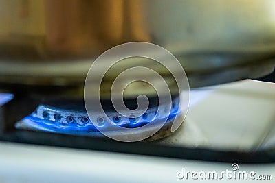Burning gas of a kitchen stove. Blue fire under iron pot Stock Photo