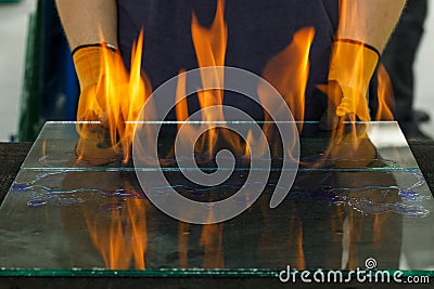Burning glass, Laminated VSG material, Cut in a glass workshop. A specialist burns through the foil breaking the glued glass Stock Photo