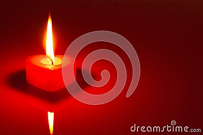 Burning heart shaped candle Stock Photo