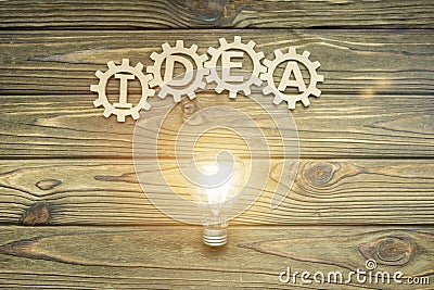 A burning light bulb and gears with a text idea. Stock Photo