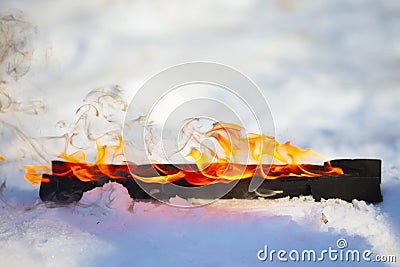 Burning log in the snow Stock Photo