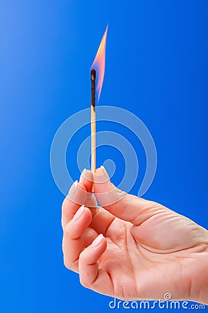 Burning matchstick held between the fingers Stock Photo