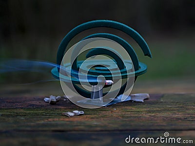 Burning of the mosquito coil in nature. Mosquito-repelling incense with a whiff of smoke Stock Photo